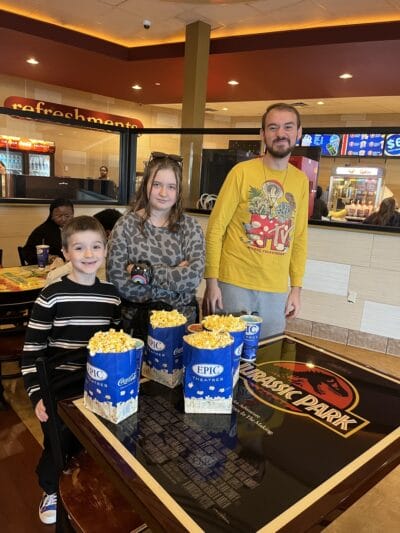 pessoas felizes no cinema com pipocas