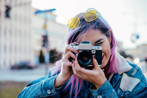Menina a tirar uma fotografia com a sua máquina fotográfica