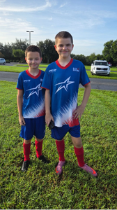 O Lucas e o Gabriel a jogar futebol.